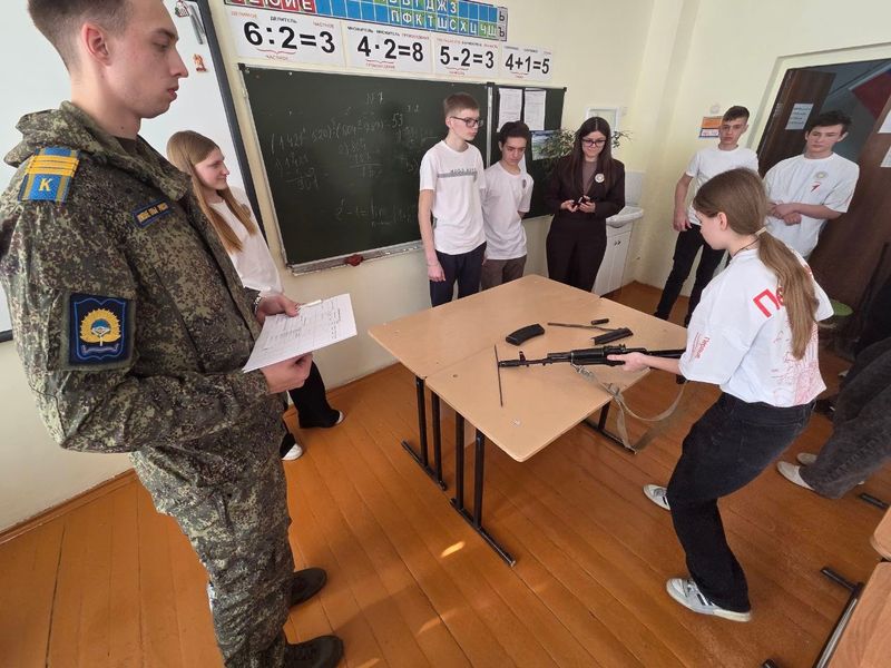 Школьники собирали автомат, натягивали противогаз и на бегу обходили препятствия под присмотром будущих офицеров